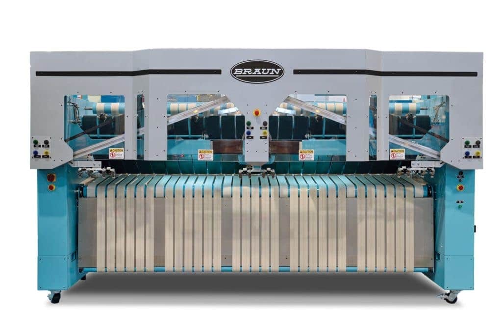 Braun industrial laundry machine with white conveyer belts on teal base